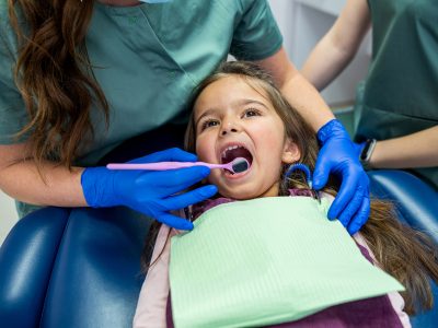 a little girl is treated for small teeth in a dental chair by a qualified pediatrician. The concept of dental treatment in toddlers